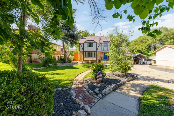 Tudor-style residence with a brick and stucco facade, featuring dark timber accents and a vibrant blue entry door