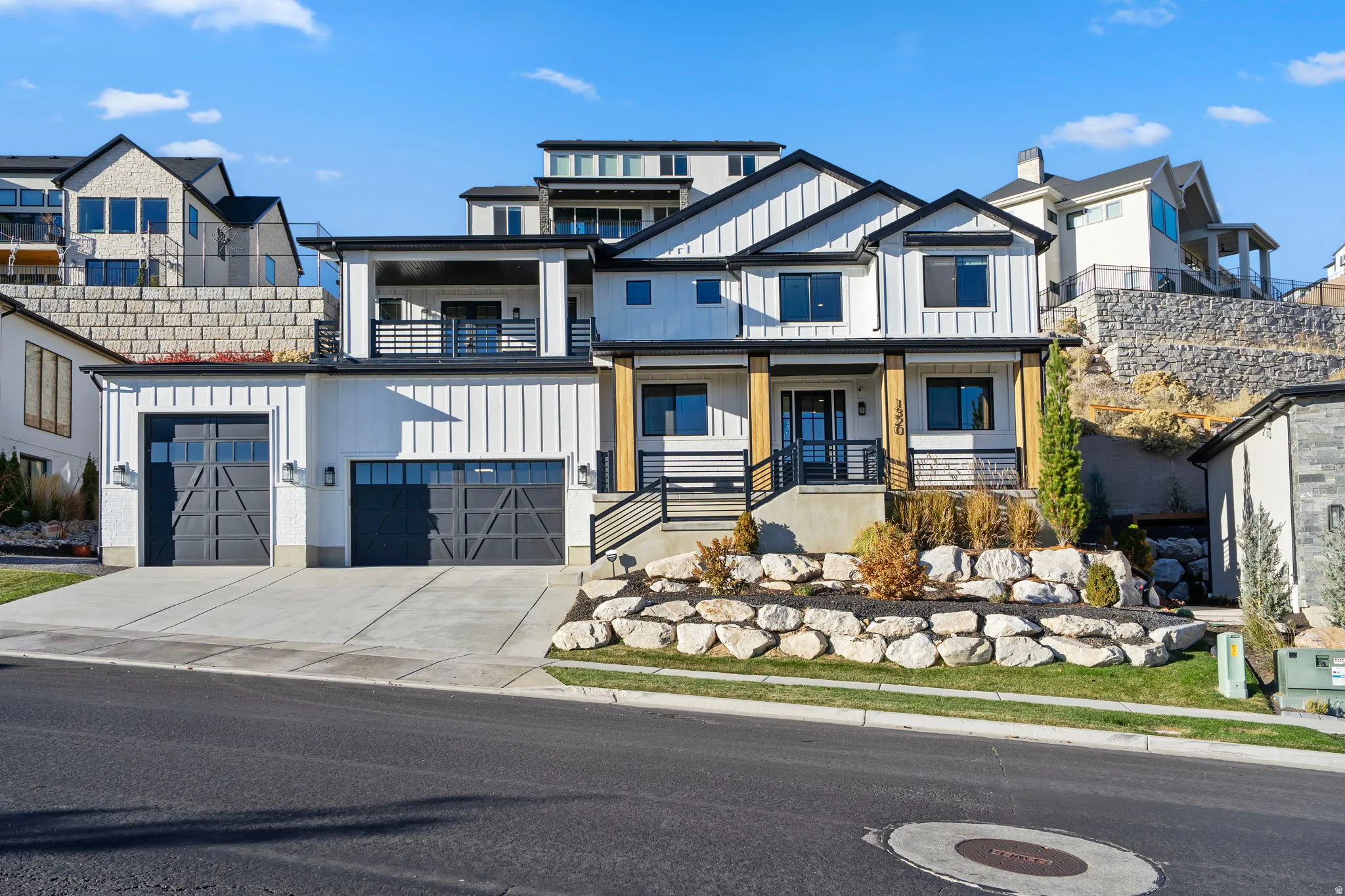 Modern farmhouse exterior featuring white vertical siding, black trim, and a prominent front entrance