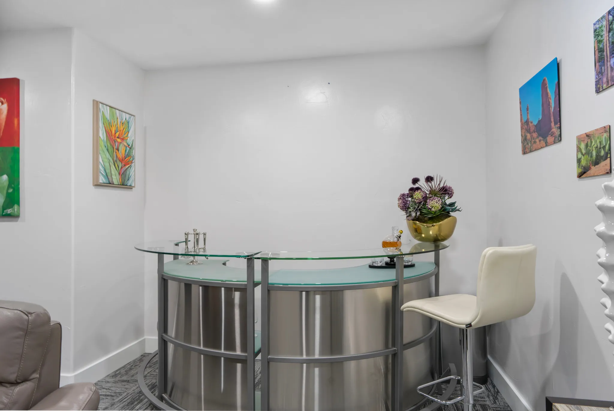 Built-in bar featuring a glass countertop, brushed metal base, and integrated sink
