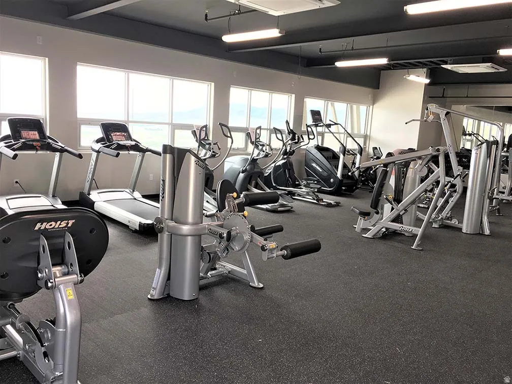 HOA Amenities Fitness center featuring multiple treadmills, elliptical machines, and strength training equipment