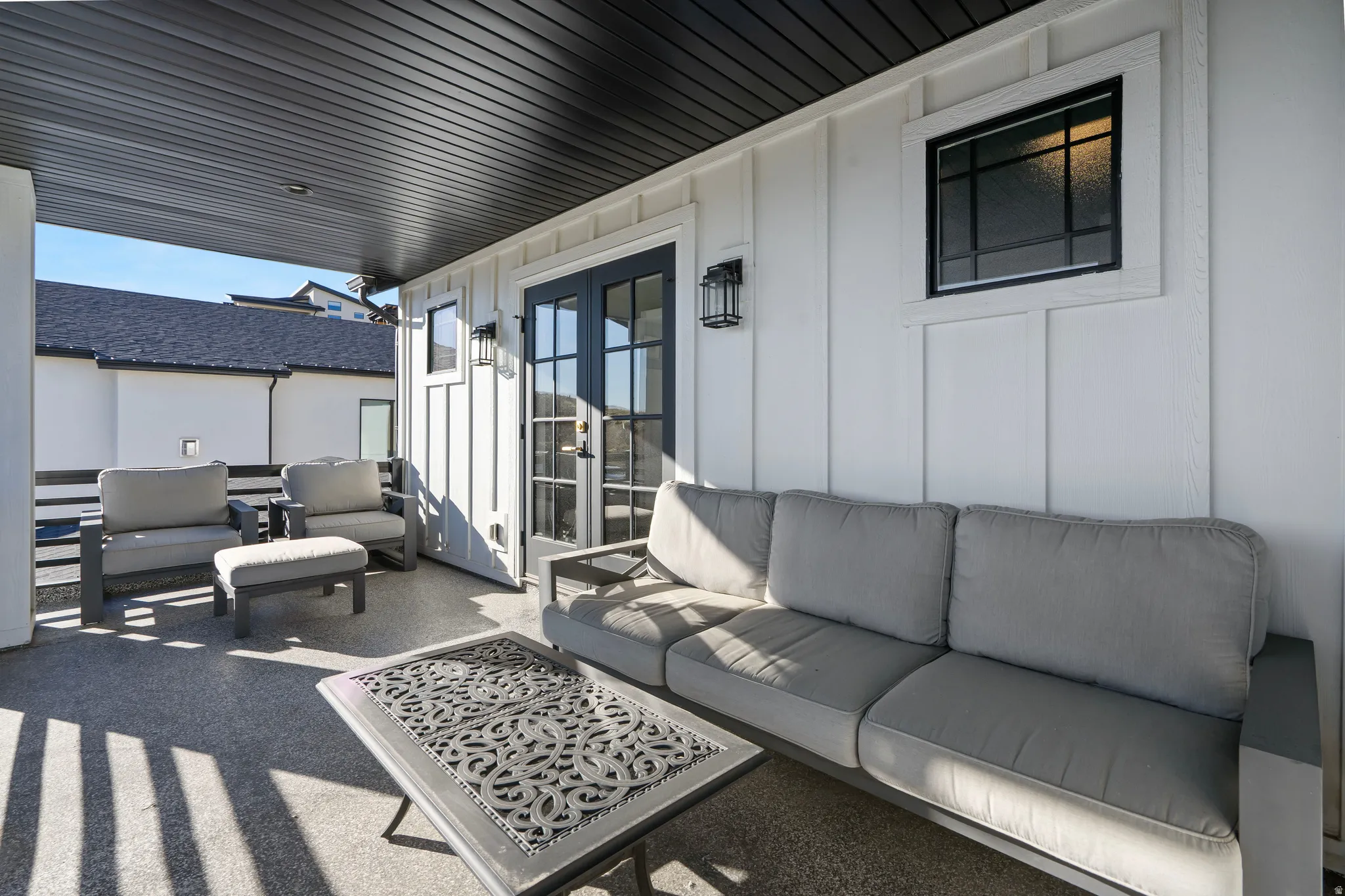 Covered outdoor patio featuring a dark slatted ceiling and textured flooring
