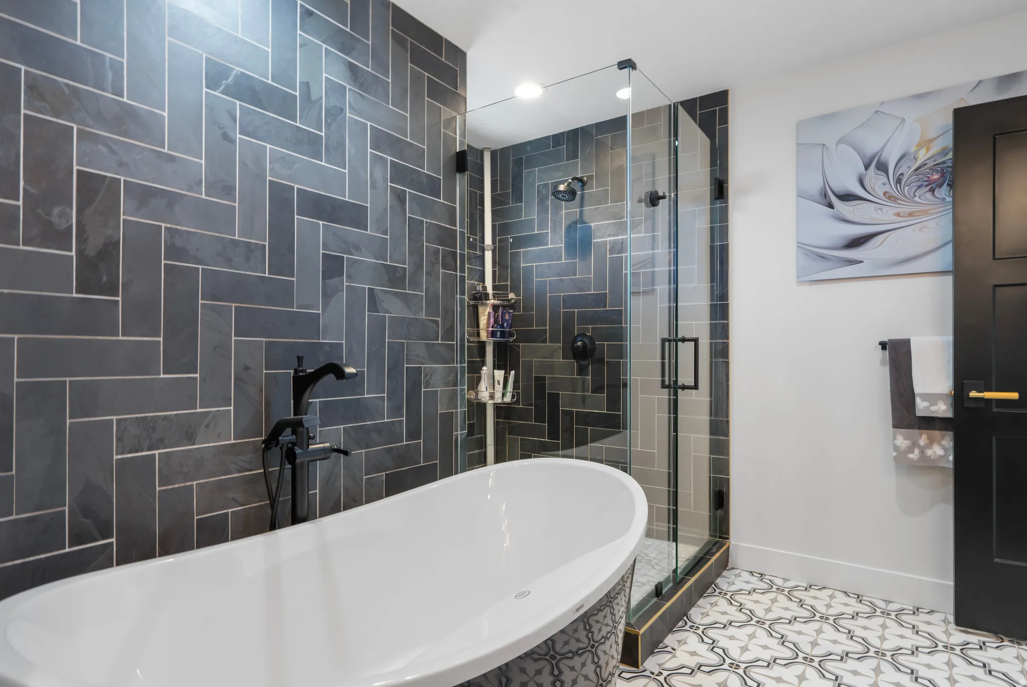 Freestanding soaking tub with floor-mounted matte black faucet