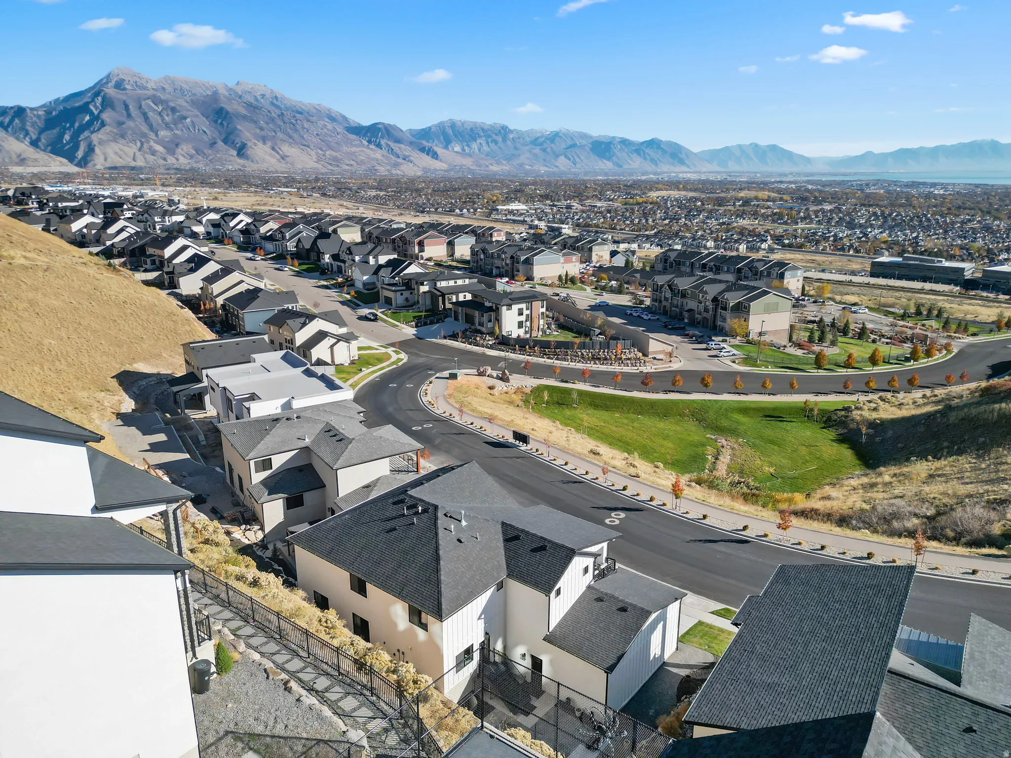 Expansive mountain backdrop with a collection of modern residences featuring pitched roofs and varied exterior finishes