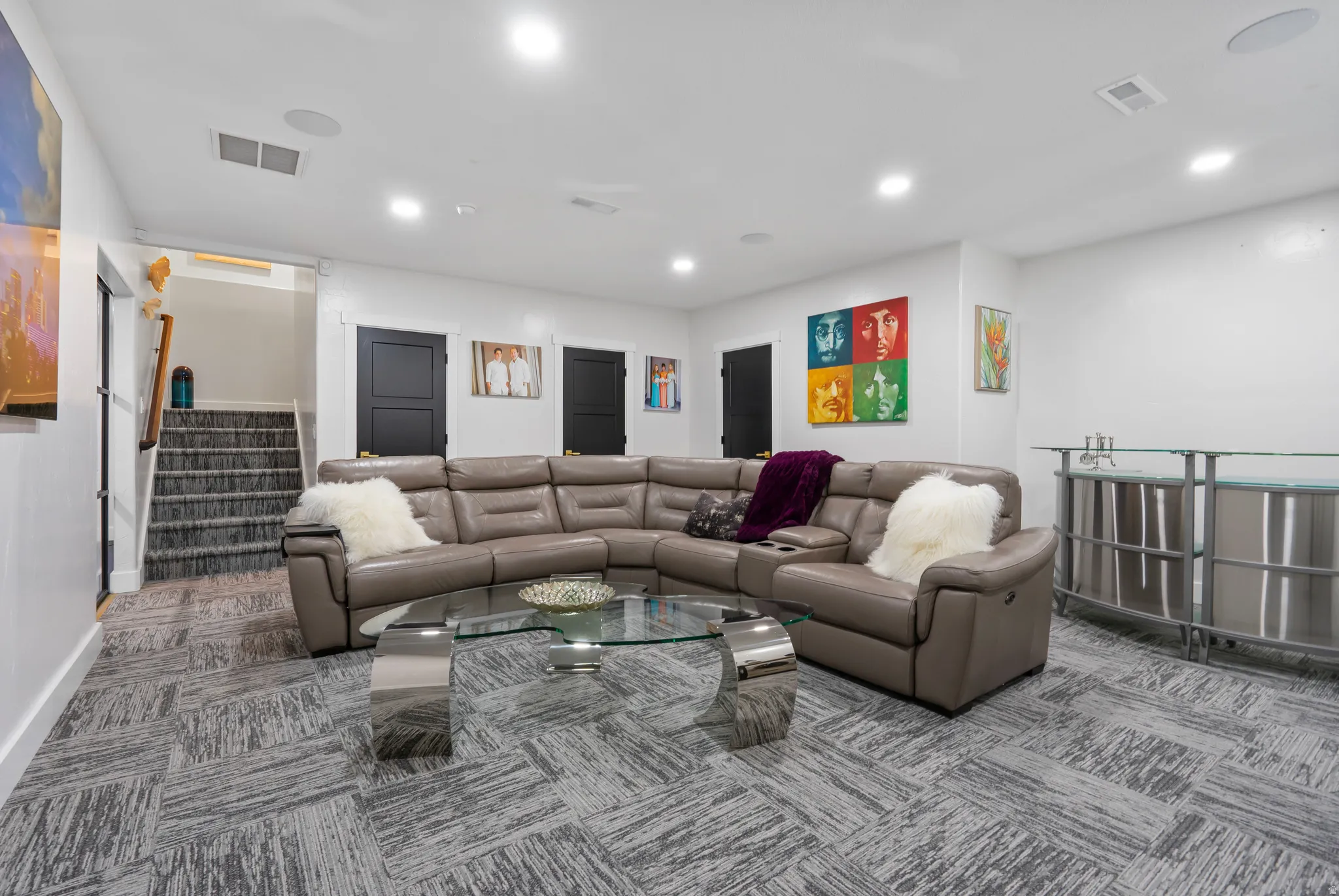 Spacious room featuring patterned carpet flooring, recessed lighting, and a built-in bar area with a glass countertop