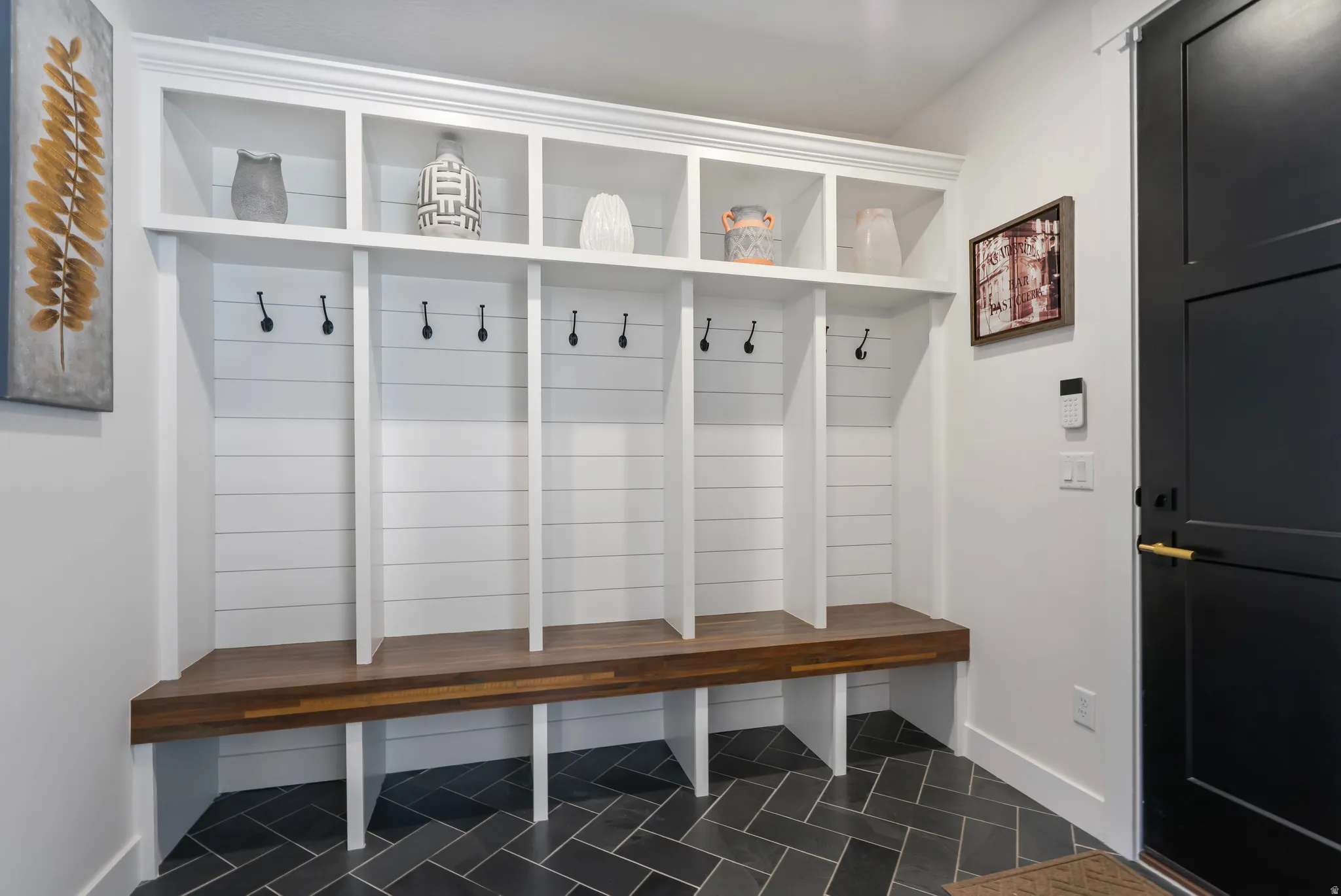 Built-in mudroom seating with a wood-finish benchtop, shiplap backing, and overhead cubby storage