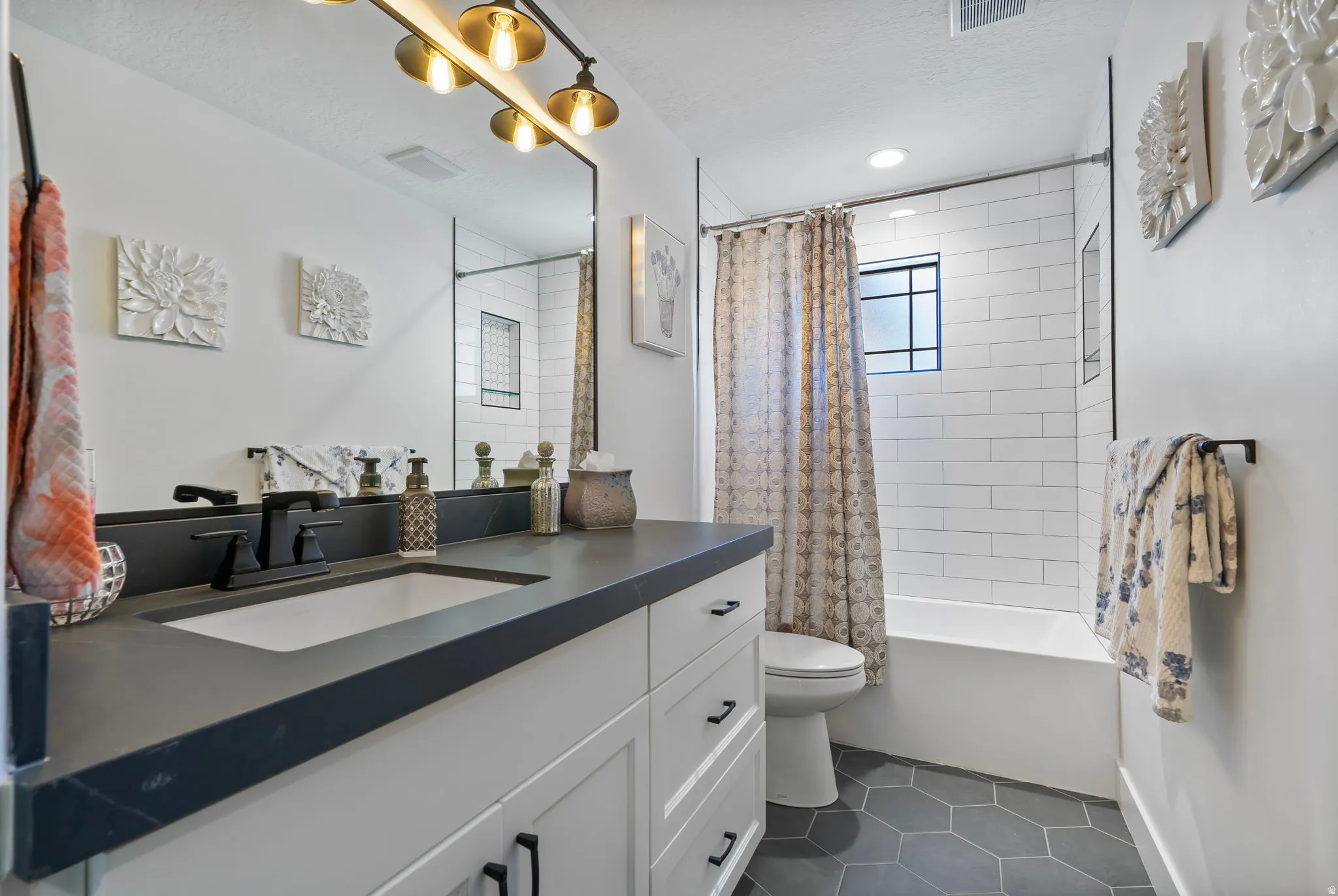 Bathroom featuring a white vanity with a dark countertop, an undermount sink, and matte black fixtures