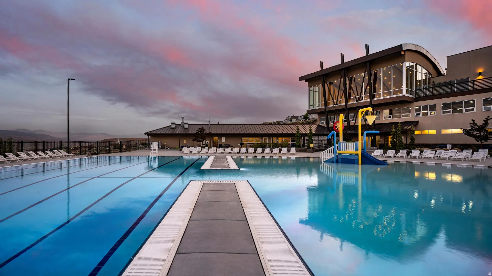 HOA Amenities Expansive outdoor pool area with multiple swimming lanes and a built-in water play structure