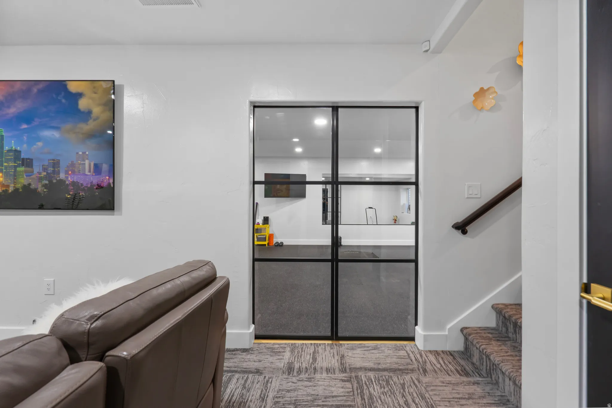 Double black-framed glass doors open to an interior space with recessed lighting