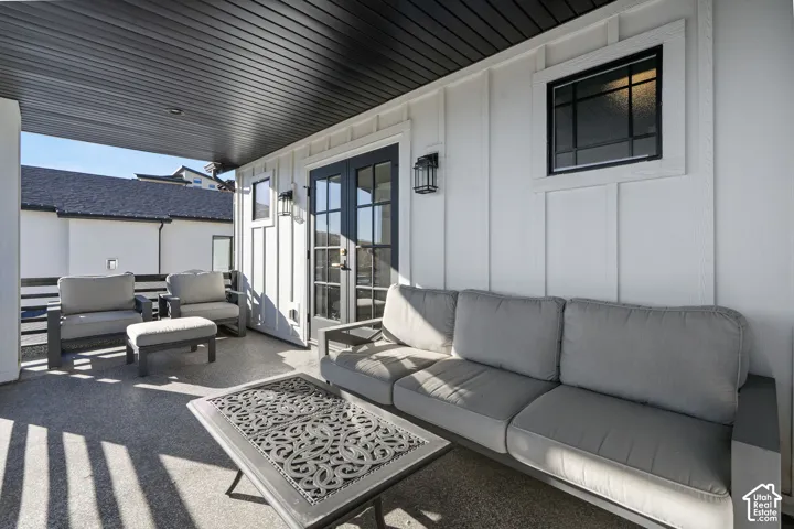 Covered outdoor patio featuring a dark slatted ceiling and textured flooring