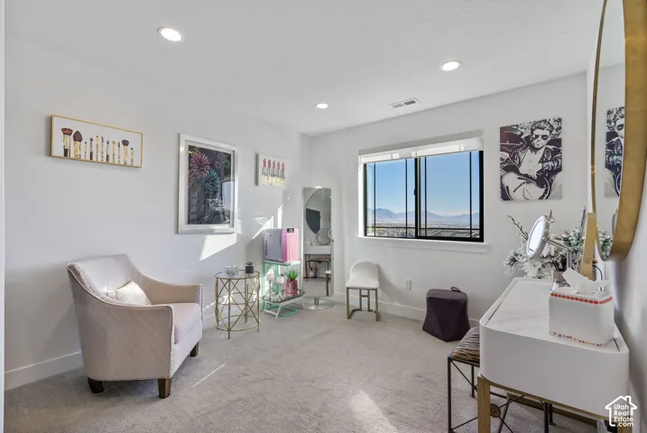 Carpeted interior space featuring white walls and recessed lighting