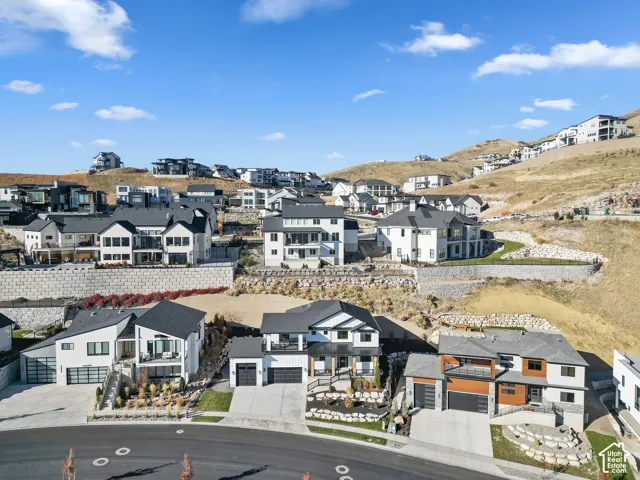 Contemporary hillside residences featuring varied architectural designs, attached garages, and engineered retaining walls