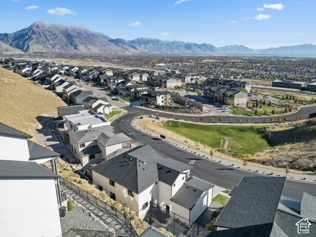 Expansive mountain backdrop with a collection of modern residences featuring pitched roofs and varied exterior finishes