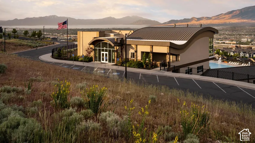 HOA Amenities Modern building featuring a distinctive curved roofline, expansive glass entry, and a multi-level design