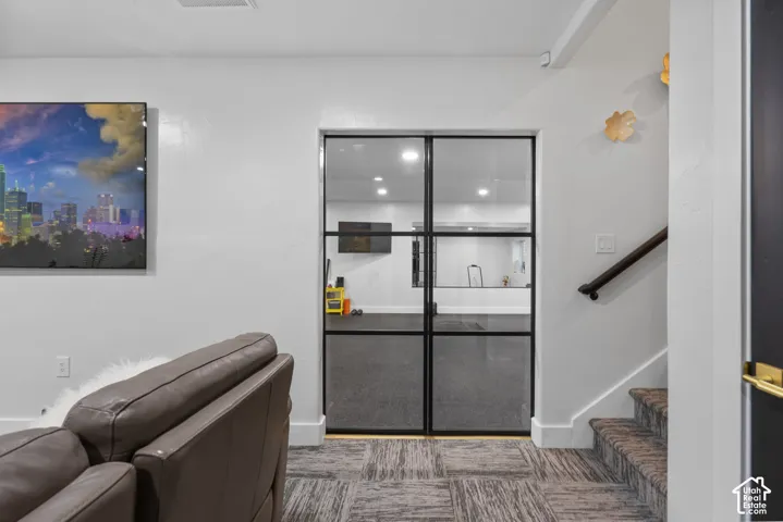 Double black-framed glass doors open to an interior space with recessed lighting