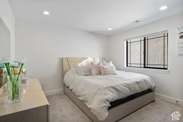 Carpeted room featuring recessed lighting, a window with dark framing, and light-colored walls