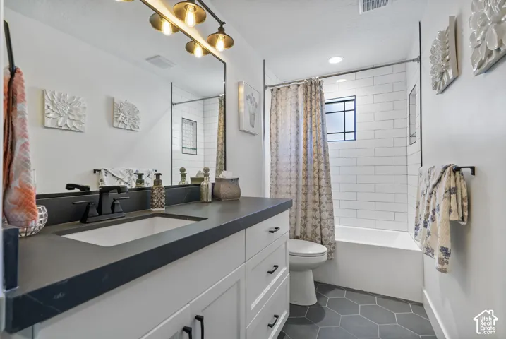 Bathroom featuring a white vanity with a dark countertop, an undermount sink, and matte black fixtures