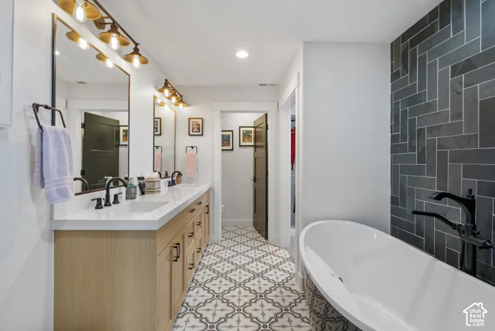 Freestanding soaking tub with floor-mounted faucet