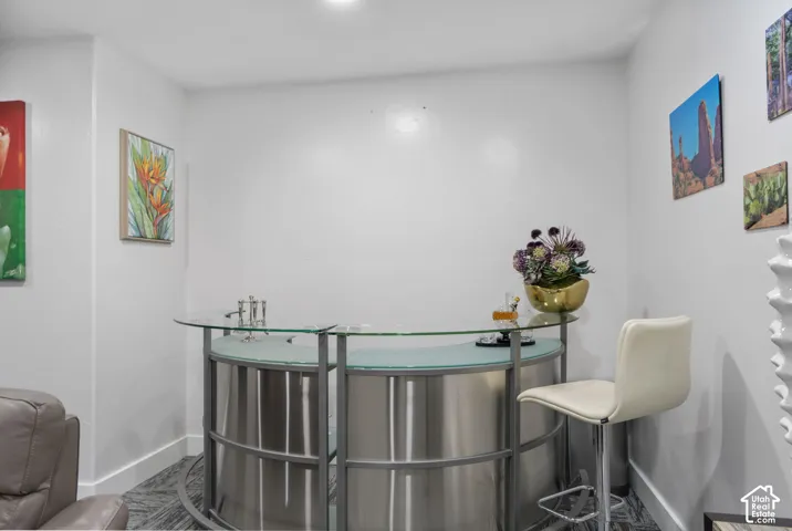 Built-in bar featuring a glass countertop, brushed metal base, and integrated sink