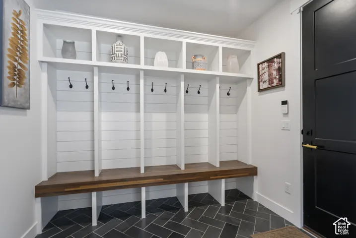 Built-in mudroom seating with a wood-finish benchtop, shiplap backing, and overhead cubby storage