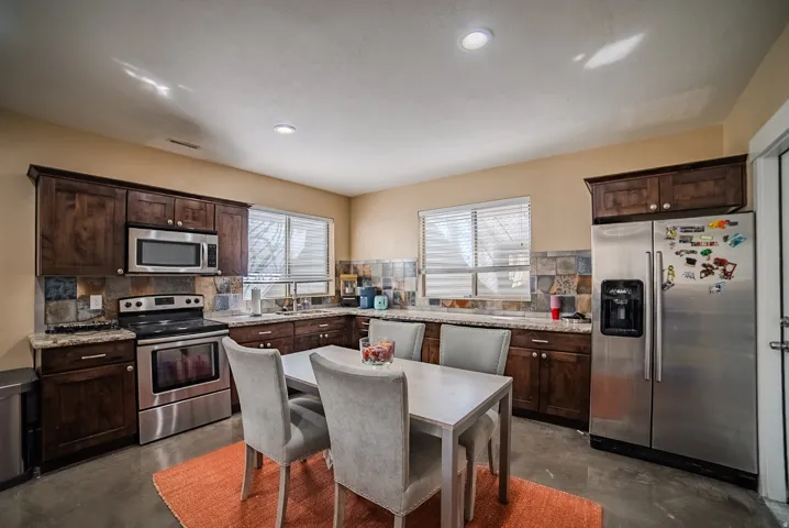 Kitchen featuring rich wood cabinetry, stainless steel appliances, and solid surface countertops