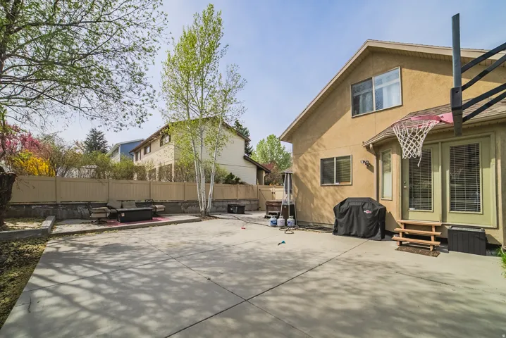 Spacious concrete patio area featuring a basketball hoop