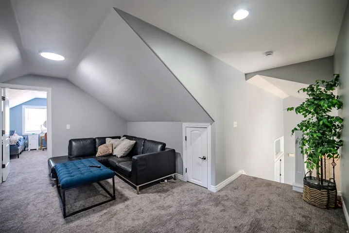 Upper level landing featuring sloped ceilings, recessed lighting, and a skylight