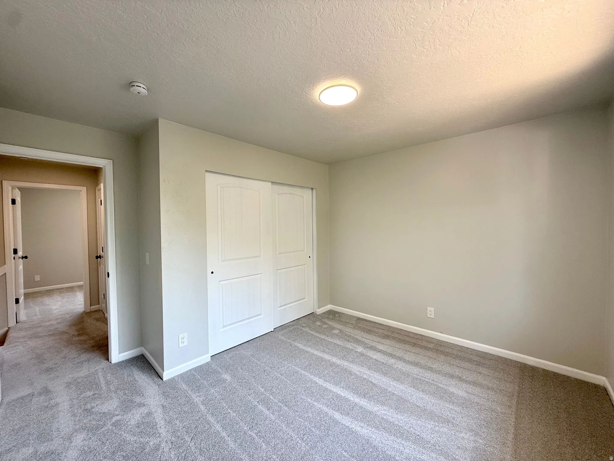 Spacious room with plush gray carpeting and light neutral wall finishes