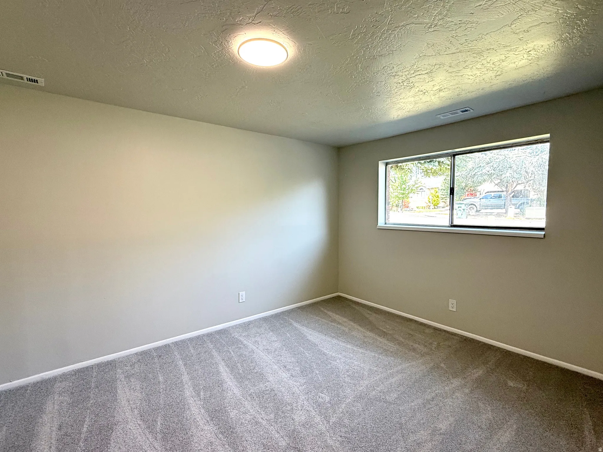Interior room featuring light gray walls and a textured ceiling