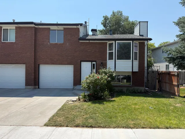 Brick facade townhouse with a two-car garage, bay window, and a front entry door with transom window