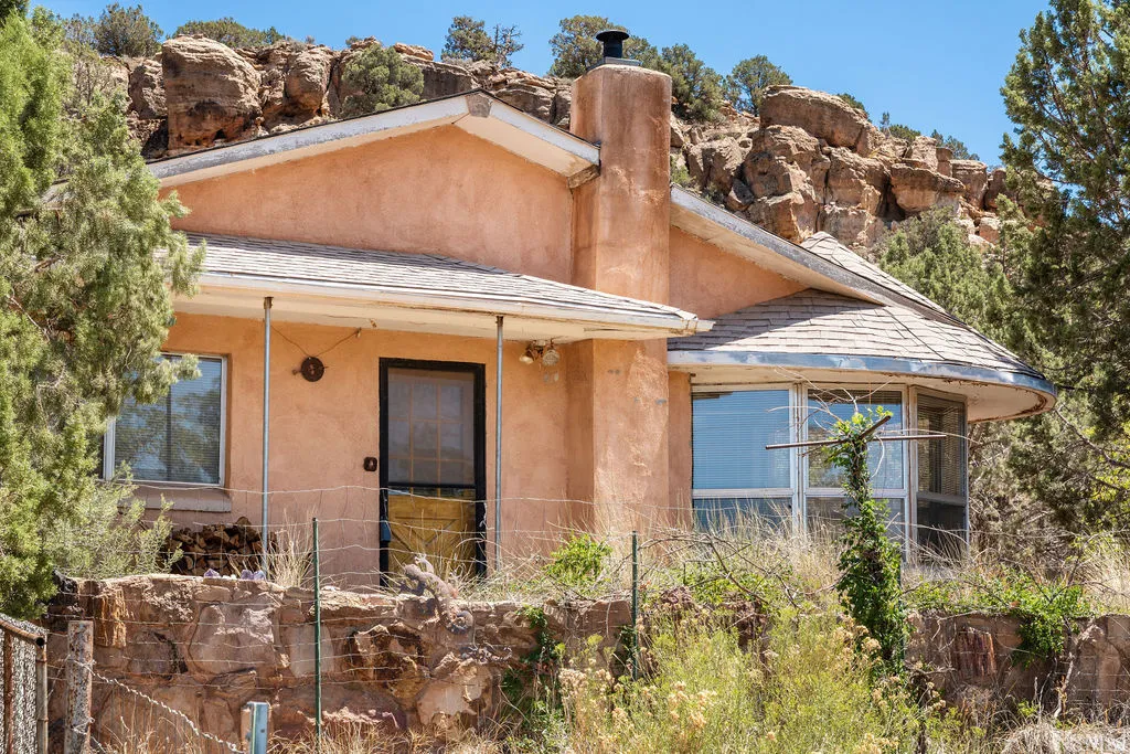 Charming Pueblo Revival residence nestled against dramatic red rock formations