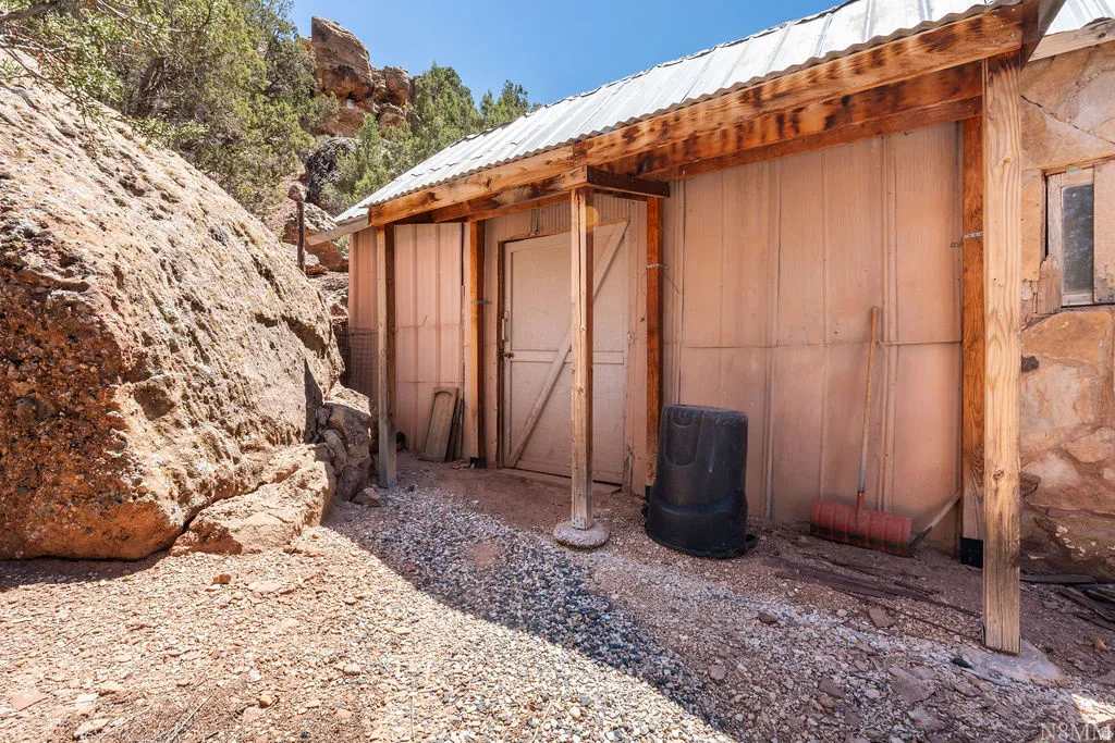 Rustic outbuilding with wood beam support posts and a corrugated metal roof
