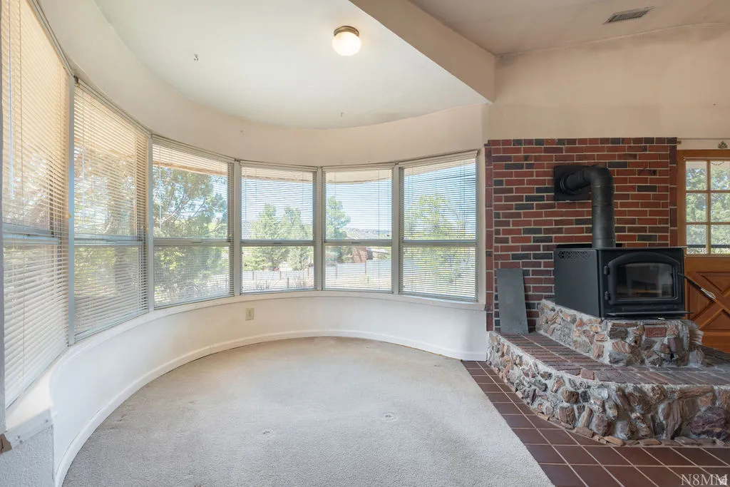 Sunroom with curved bay windows offering abundant natural light and expansive sightlines to outdoor surroundings