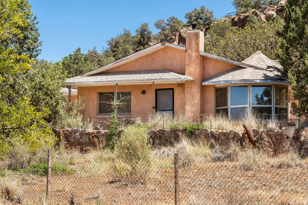 Southwestern-style residence featuring a stucco exterior with a pitched roof and chimney