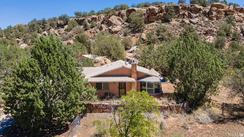 Southwestern-style residence featuring a prominent chimney, a screened porch, and a light-toned shingle roof