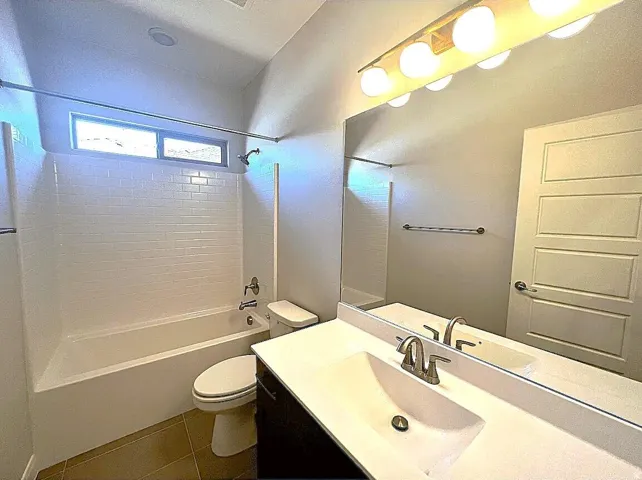 Modern bathroom featuring a single vanity with a rectangular undermount sink, a large wall mirror, and a five-bulb vanity light fixture