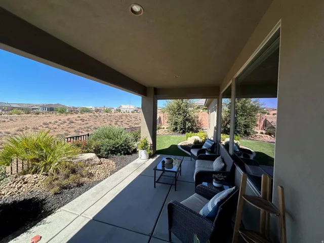Covered patio featuring recessed lighting, a concrete slab, and direct access to a landscaped yard with a lawn and rock features