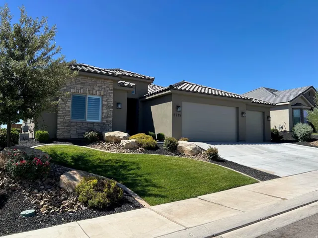 Single-story residence featuring a stucco exterior with stone accents and a tile roof