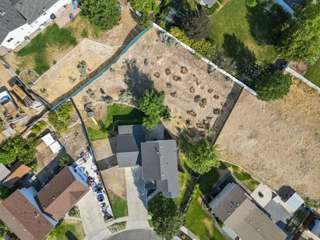 Expansive property featuring a large undeveloped lot, mature trees, and fencing