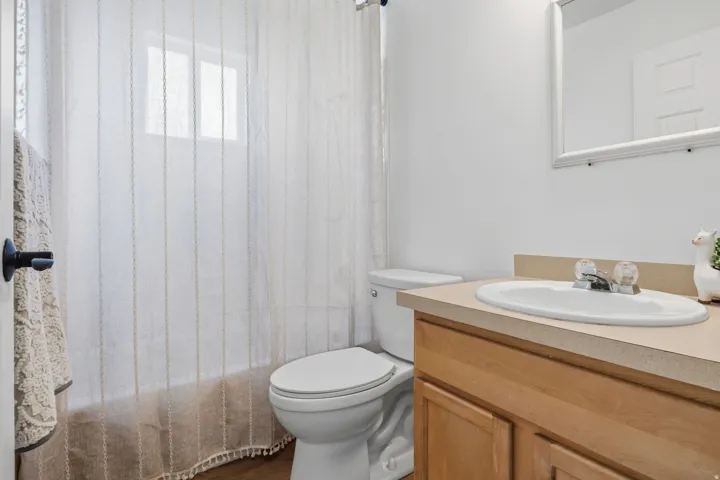 Bathroom vanity with a light wood-finish cabinet, integrated sink, and laminate countertop