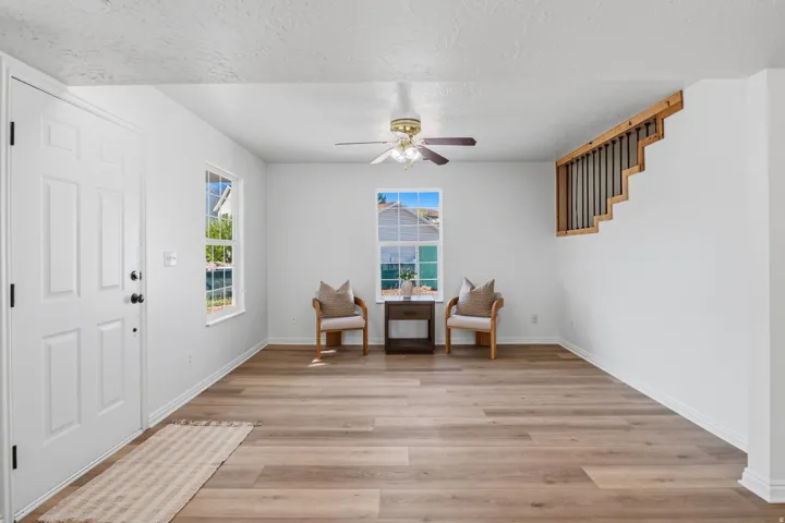 Bright entry space featuring wood-finish flooring, white walls, and a multi-pane window