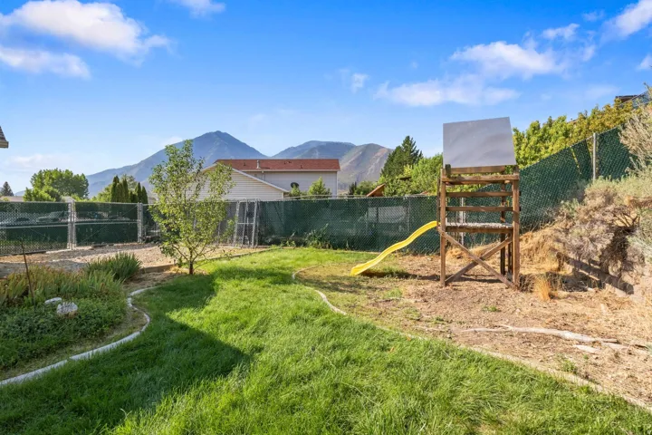 Expansive backyard oasis featuring mature landscaping, manicured lawn, and established trees