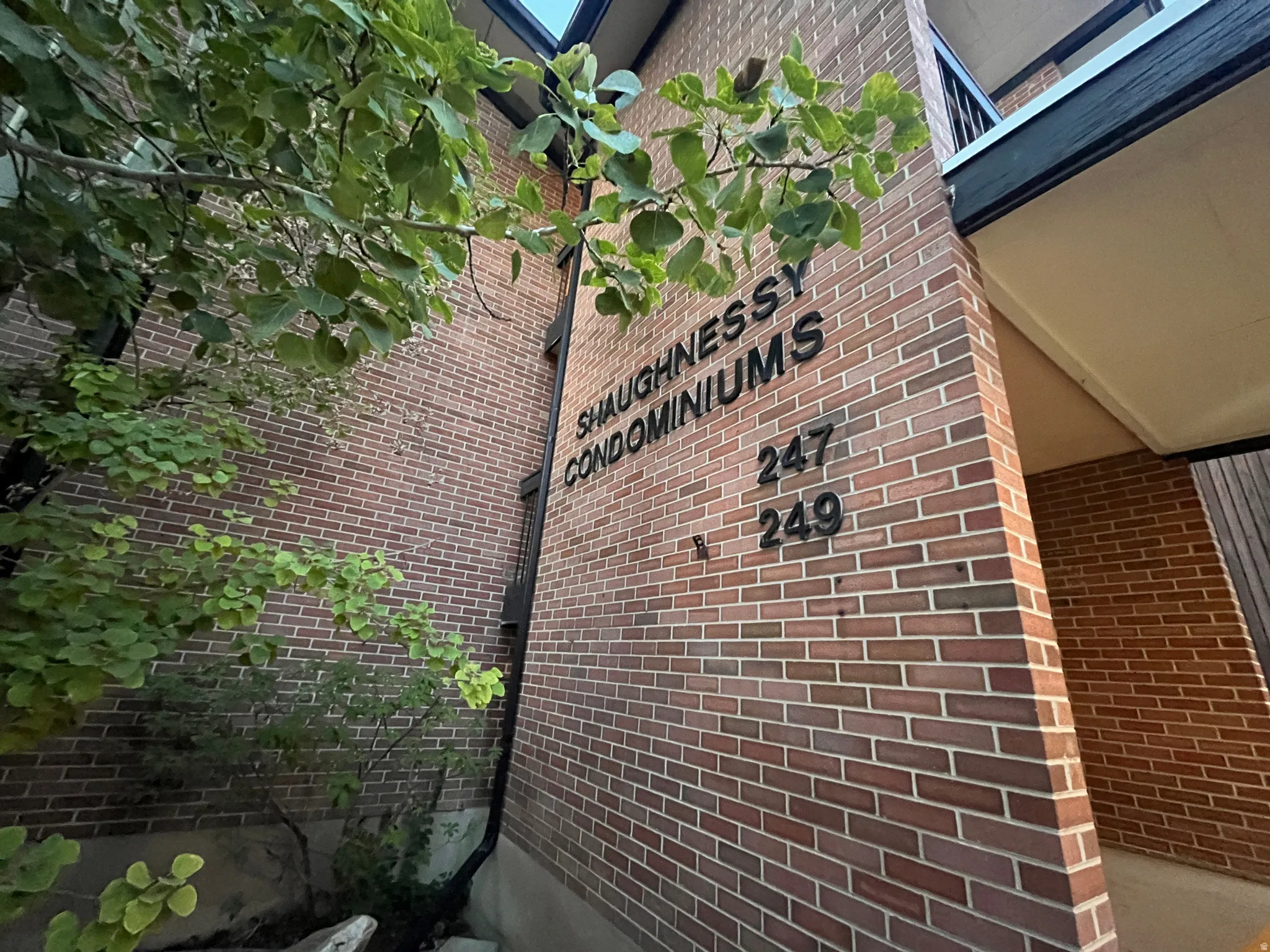 Brick condominium building featuring professional signage and unit identification