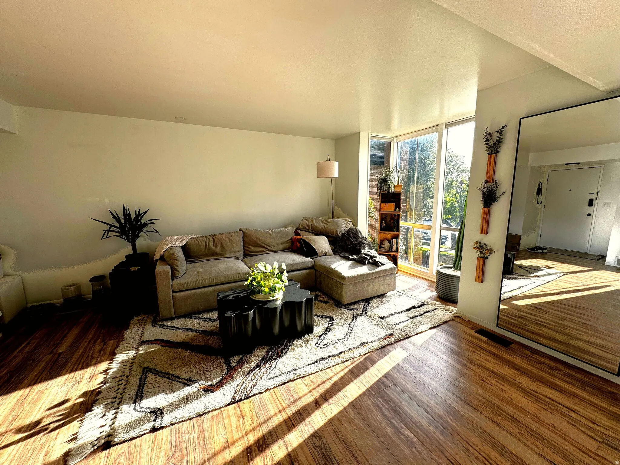 Living area featuring large windows, wood-finish flooring, and a recessed ceiling