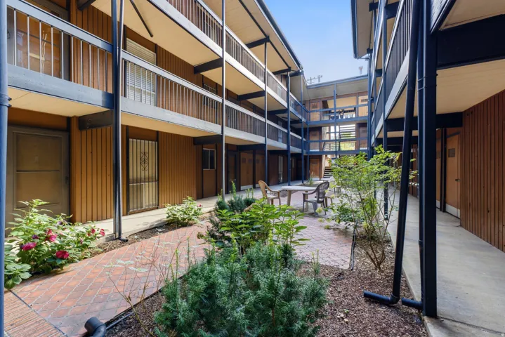 Central courtyard with a brick paver patio, established landscaping, and multi-level walkways