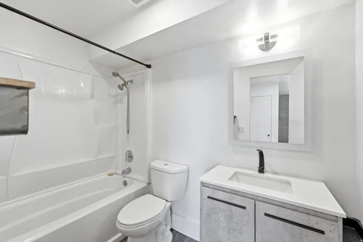 Modern vanity with a rectangular sink, white countertop, and matte black faucet