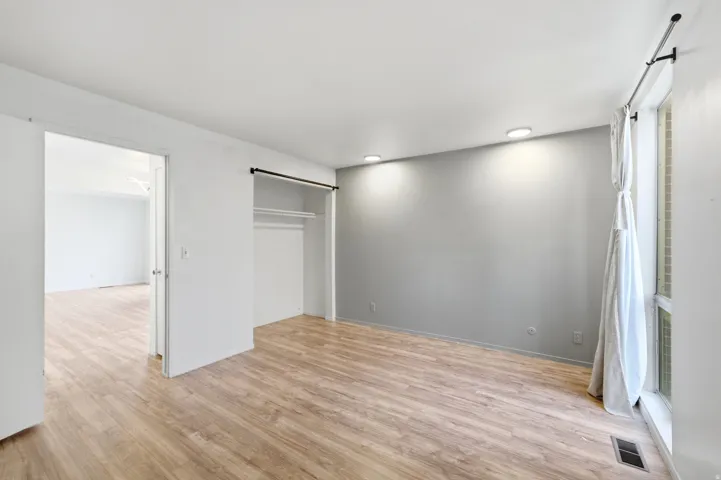 Wood-finish flooring, recessed lighting, and a window with a curtain rod