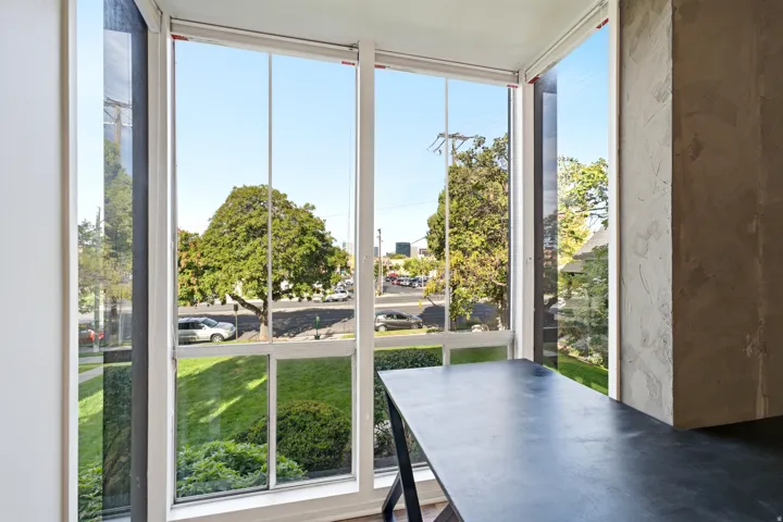 Floor-to-ceiling windows with white frames and a built-in dark countertop