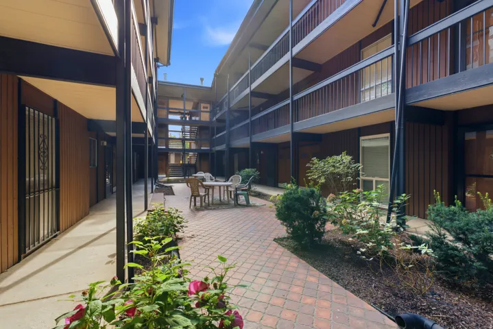 Courtyard with brick paver hardscaping, perimeter planting beds, and multi-story corridors