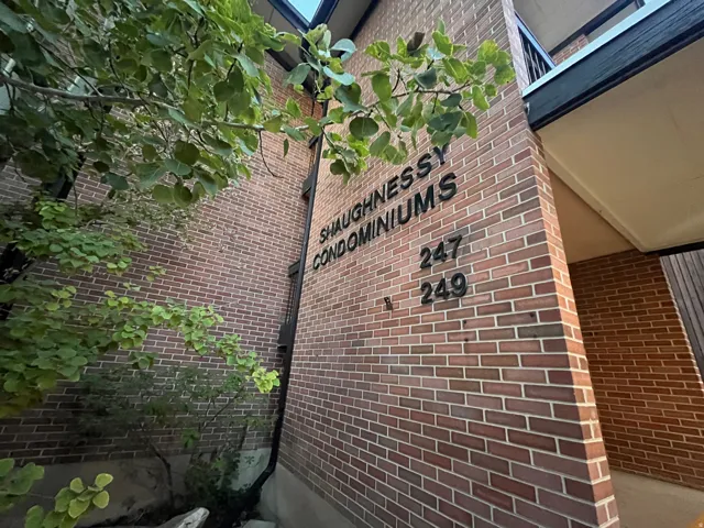 Brick condominium building featuring professional signage and unit identification
