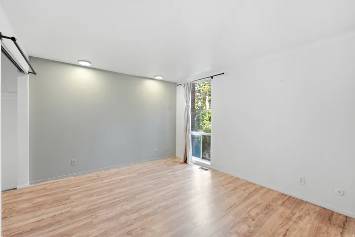 Wood-finish flooring, recessed lighting, and a large window with vertical panes